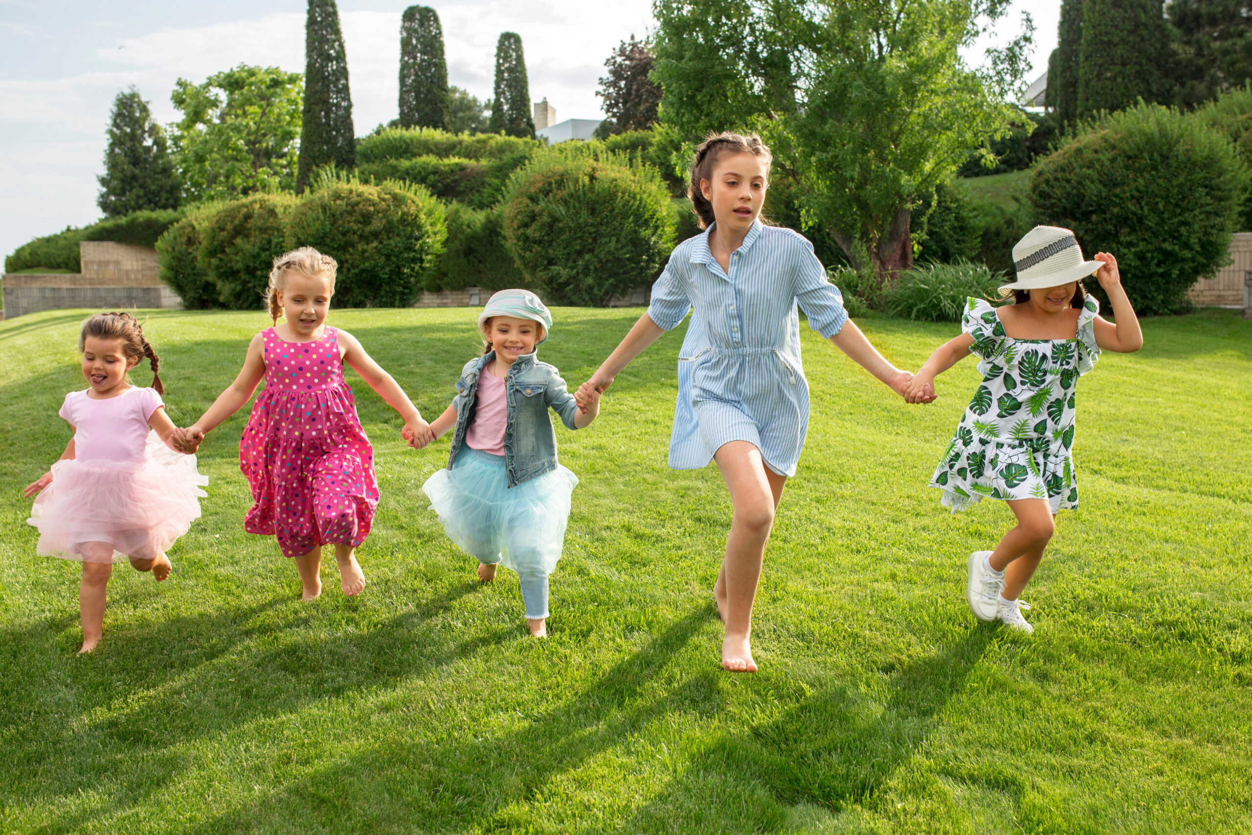 Funny starts. Kids fashion concept. The group of teen boys and girls running at park. Children colorful clothes, lifestyle, trendy colors concepts.