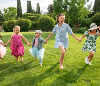 Funny starts. Kids fashion concept. The group of teen boys and girls running at park. Children colorful clothes, lifestyle, trendy colors concepts.