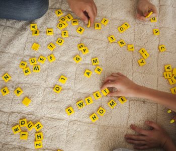 high-angle-view-hand-playing-scrabble-game-carpet